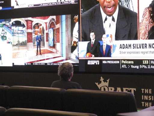 A customer watches video screens inside the DraftKings sportsbook in Atlantic City N