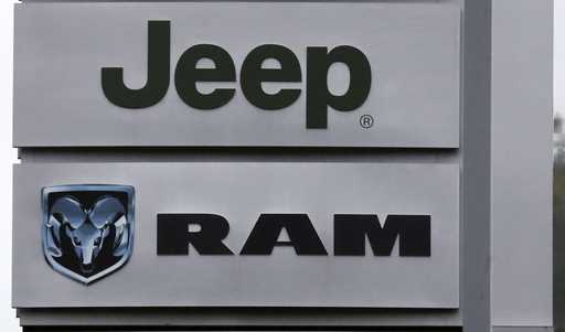 This October 1, 2014 photo shows Jeep and Dodge Ram logos on signs at a dealership in Haverhill, Ma…