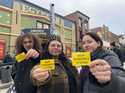 Attendees of the 2025 Sundance Film Festival hold up "Keep Sundance in Utah" stickers on Main Stree…