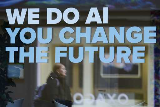 A woman is reflected in a window with a slogan about AI ahead of the World Economy Forum in Davos, …