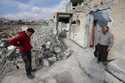 Samir al-Baghdadi, 46, left, stands on his brother Fayez outside his family's home that was destroy…