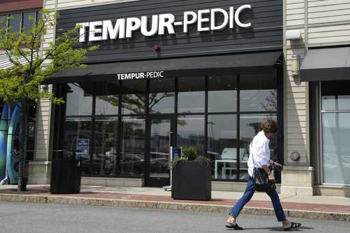 A passer-by walks near the front of a Tempur-Pedic mattress store location, May 9, 2023, in Dedham,…