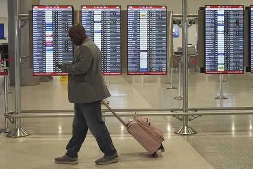 A traveler walks to his gate at Miami International Airport, Tuesday, November 26, 2024, in Miami