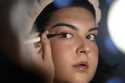 Daniella López White, of Hawaii, uses a mirror while applying makeup, Tuesday, May 14, 2024, at her…