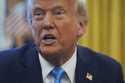 President Donald Trump speaks to reporters as he signs executive orders in the Oval Office of the W…