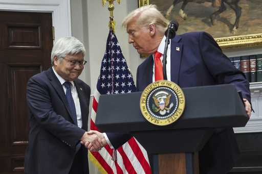 President Donald Trump shakes hands with C