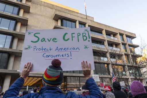 People attend a protest in support of the Consumer Financial Protection Bureau…