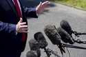 Microphones are extended as President Donald Trump speaks with reporters on the South Lawn of the W…