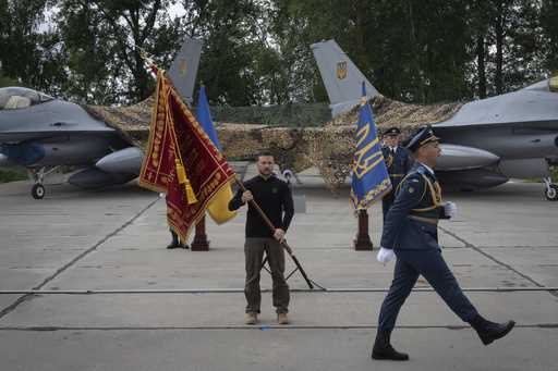 Ukraine's President Volodymyr Zelenskyy hands over the flag of a military unit on the occasion of t…