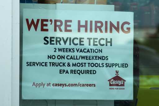 A hiring sign is displayed at a gas station in Vernon Hills, Ill