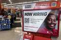 A hiring sign is displayed at a retail store in Buffalo Grove, Ill