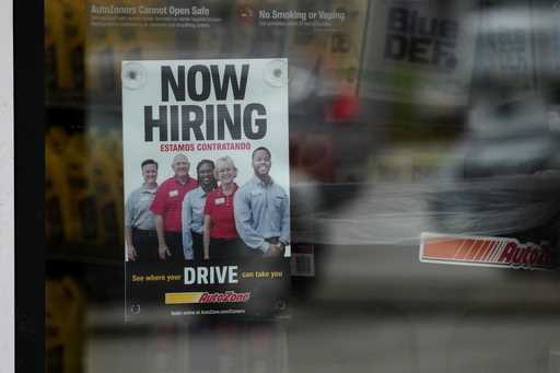 A hiring sign is displayed at a retail store in Buffalo Grove, Ill