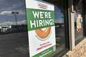 A hiring sign is displayed in the window of a Krispy Kreme donut shop on November 19, 2024, in Lone…