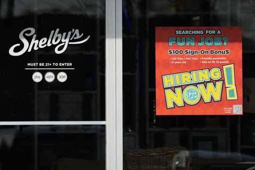 A hiring sign is displayed at a cafe in Streamwood, Ill