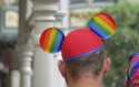 A guest wears a Pride-themed Mickey Ears hat at the Magic Kingdom at Walt Disney World, in Lake Bue…