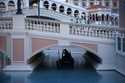 A gondolier steers his boat beneath a quiet pedestrian walkway at the Venetian hotel and casino in …