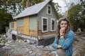 Jenny Mackenzie stands outside her flood-ravaged house in Peacham, Vt