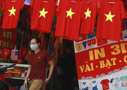 A man walks past a row of T-shirts printed with Vietnamese flags in Hanoi, Vietnam on July 30, 2020…