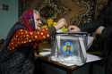 A woman casts her vote in a mobile ballot box during a presidential election runoff, in the village…