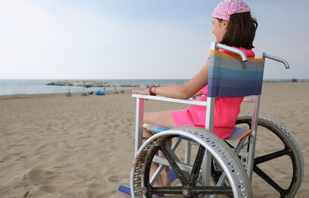 Sarepta Therapeutics stock jumped more than 30% in May 2023 following FDA approval of its Duchenne muscular dystrophy treatment, Elevidys; image of girl with muscular dystrophy on beach
