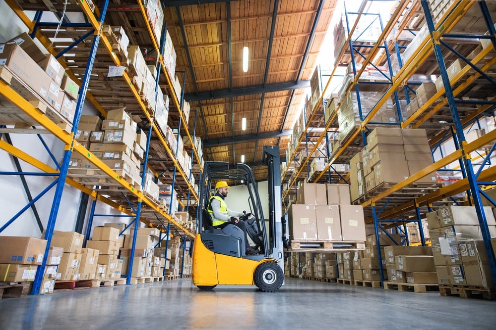 Man forklift driver working in a warehouse: Best industrial REITs to buy now