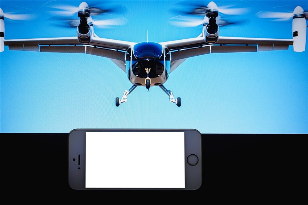 image of flying vehicle with smartphone in foreground