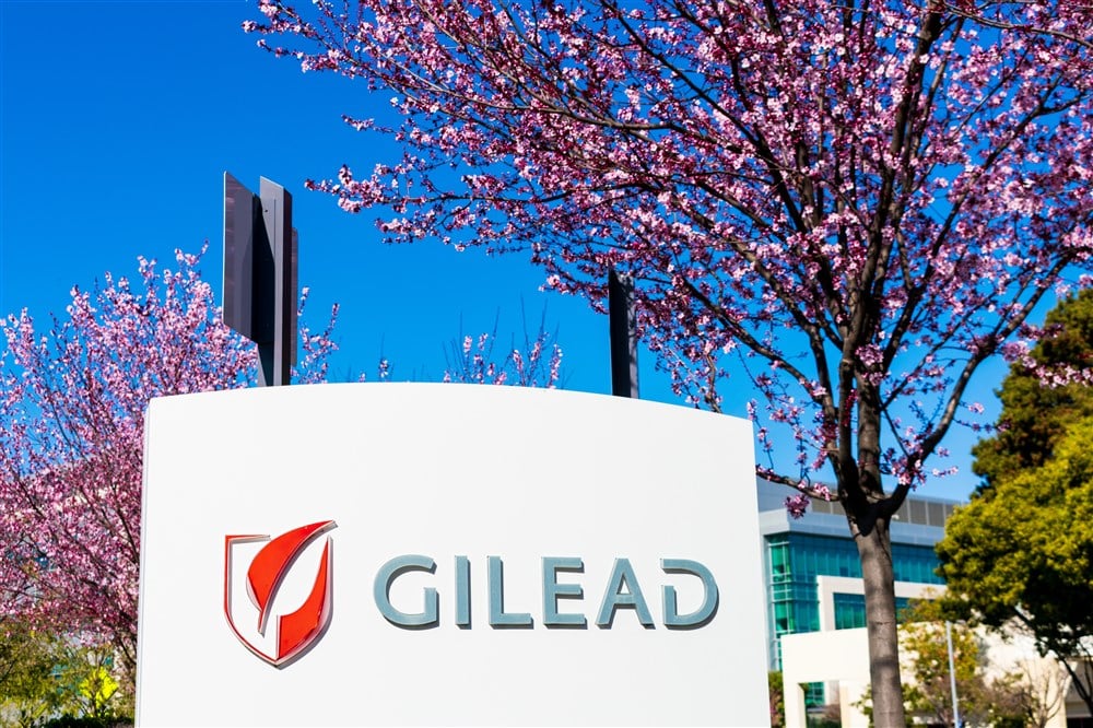 Gilead sciences logo on sign outside of building with fall sky