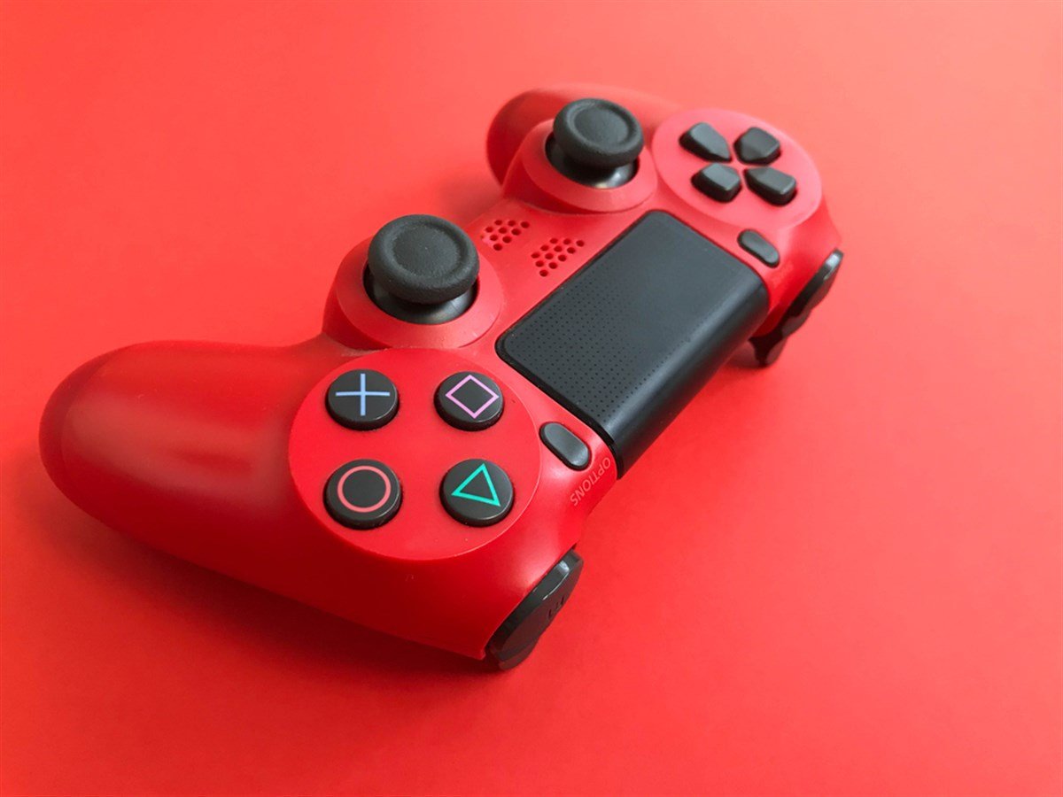 Beautiful red digital modern new game joystick for computer video games gamepad on a red background.