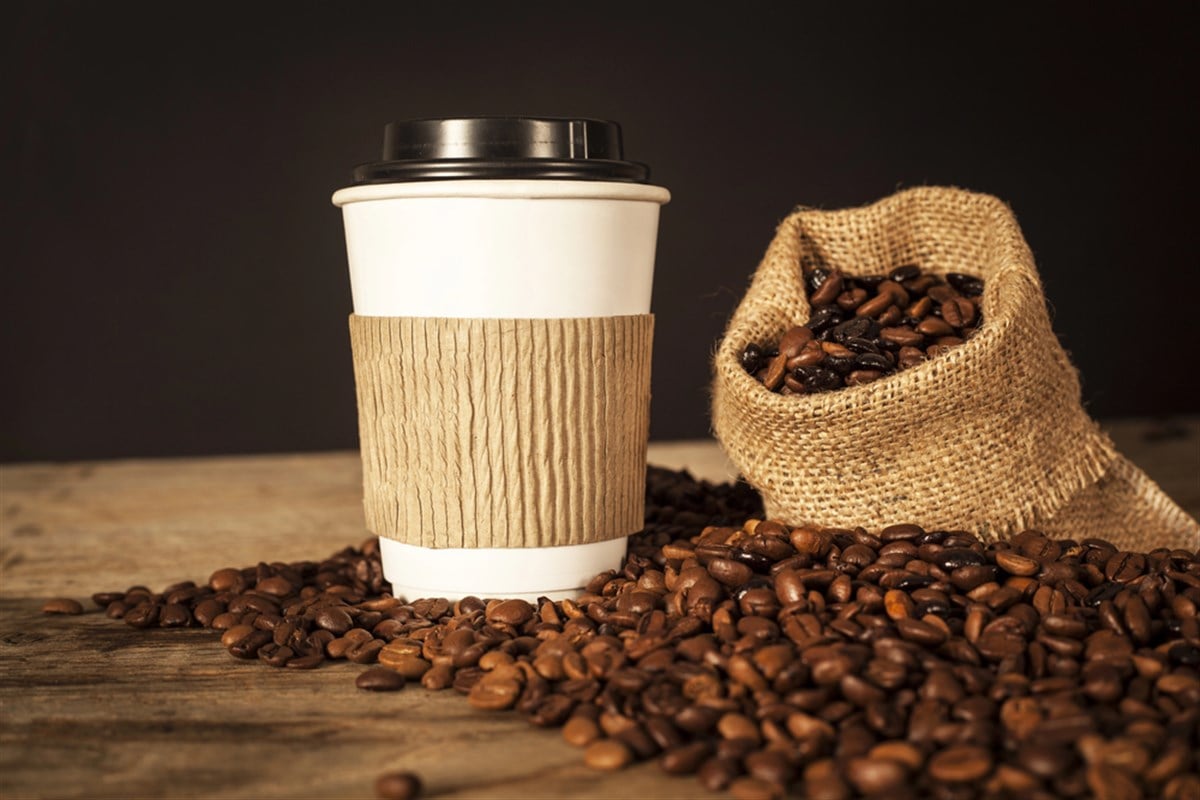 Paper cup of coffee on black background - stock image