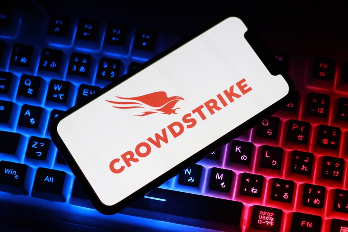 Close up view of the smartphone on neon keyboard with crowdstrike logo — Stock Editorial Photography