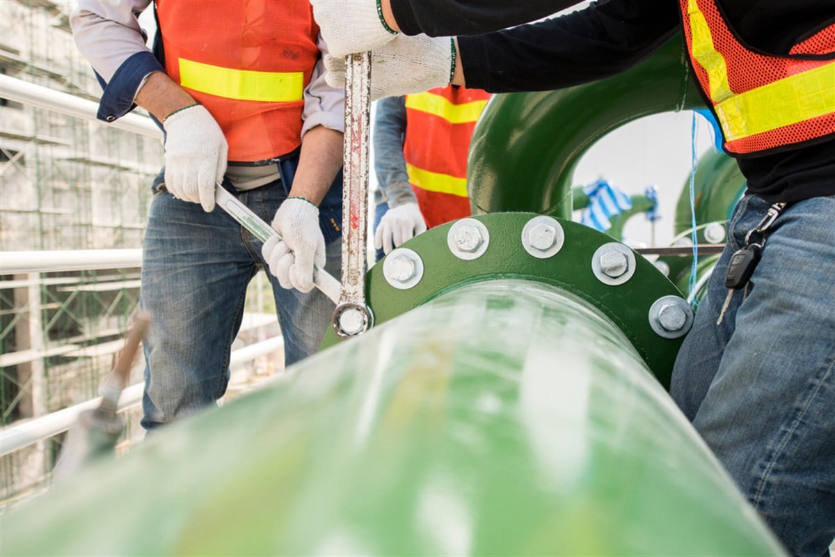 Construction worker use engineering equipment joint connection steel piping work in new construction site