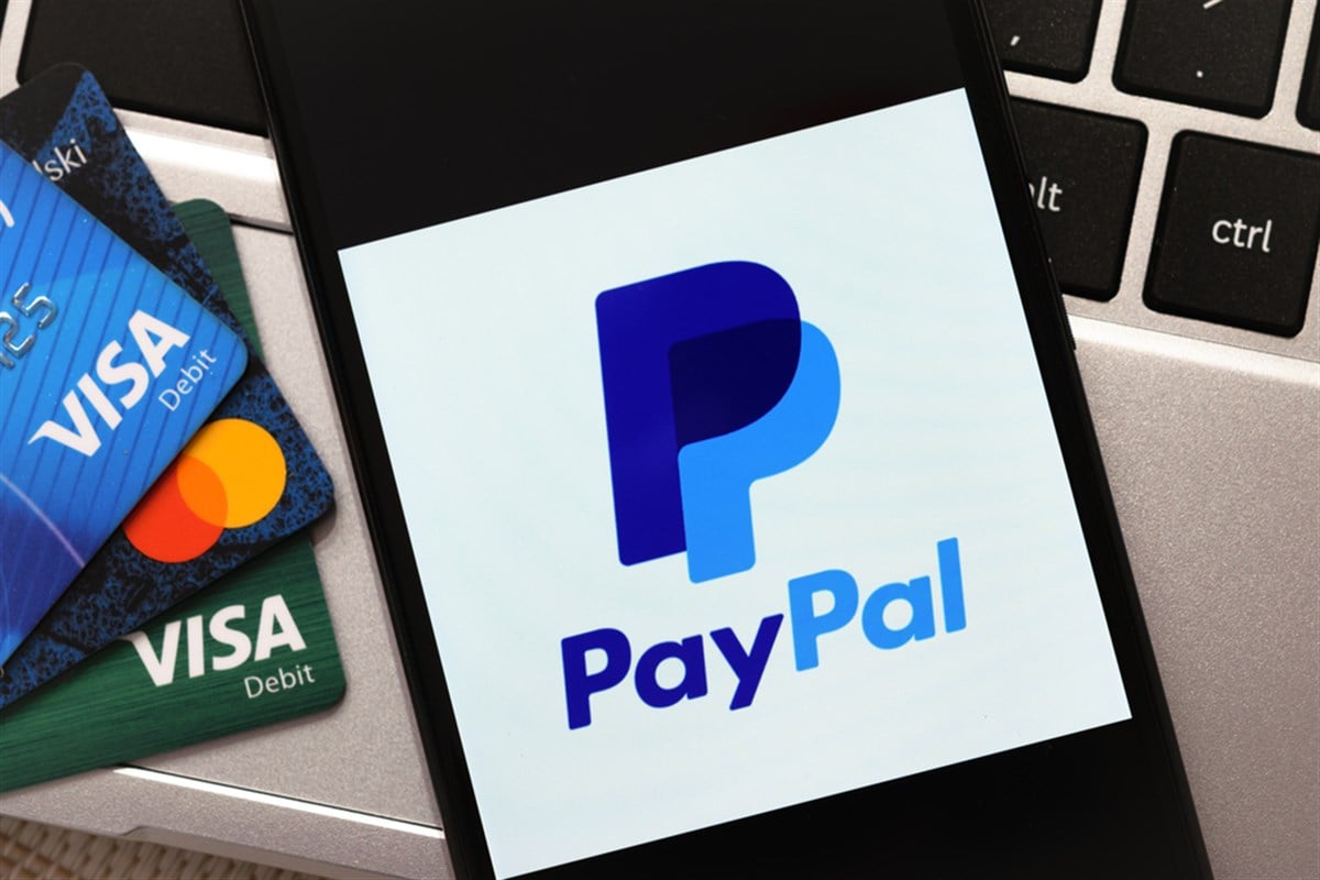 Krakow, Poland - October 16, 2020: PayPal sign on the smartphone screen next to Visa and Mastercard cards. PayPal is an online electronic finance payment system. - Stock Editorial Photography