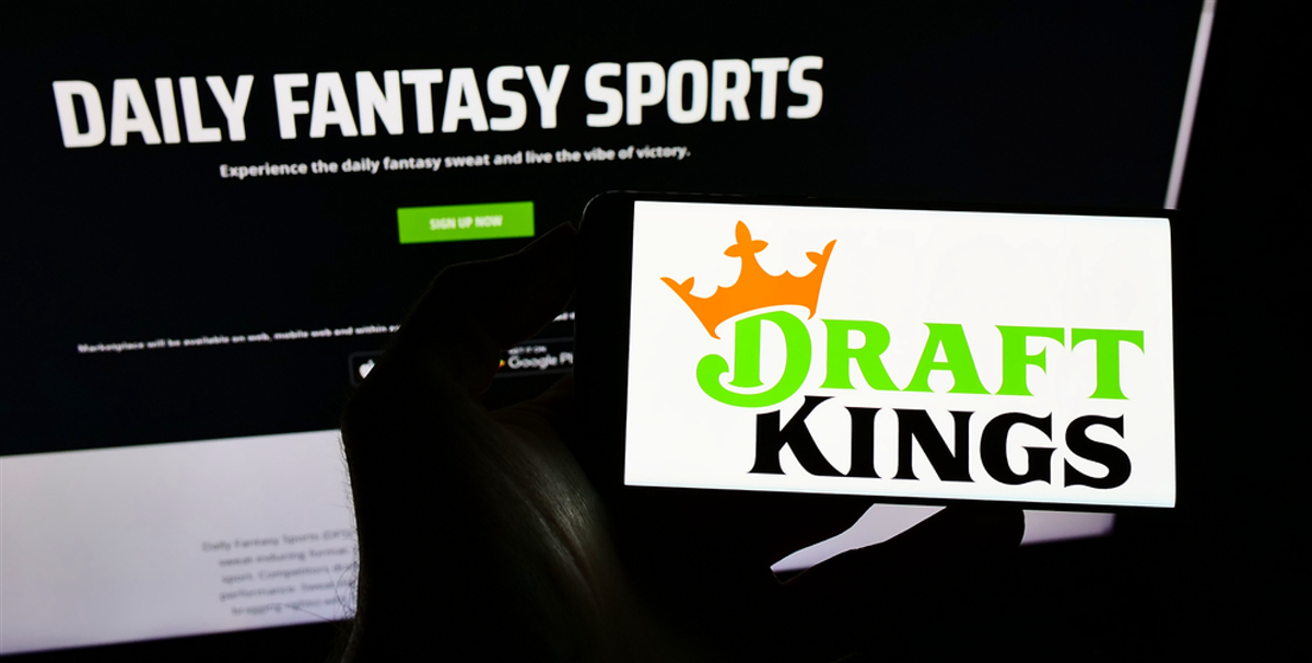 STUTTGART, GERMANY - Aug 30, 2021: Person holding cellphone with logo of American sports betting company DraftKings Inc. on screen in front of webpage. Focus on phone display. — Stock Editorial Photography