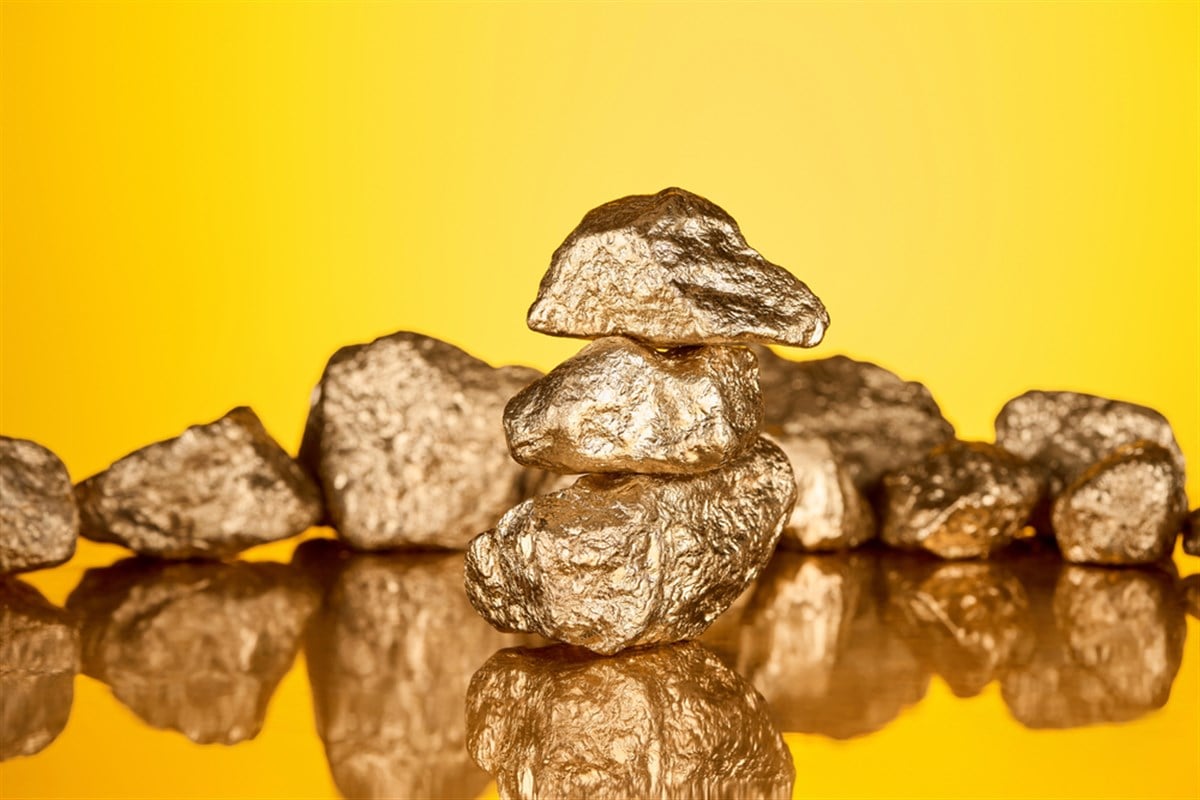 Selective focus of three gold shiny stones with reflection isolated on yellow — Photo