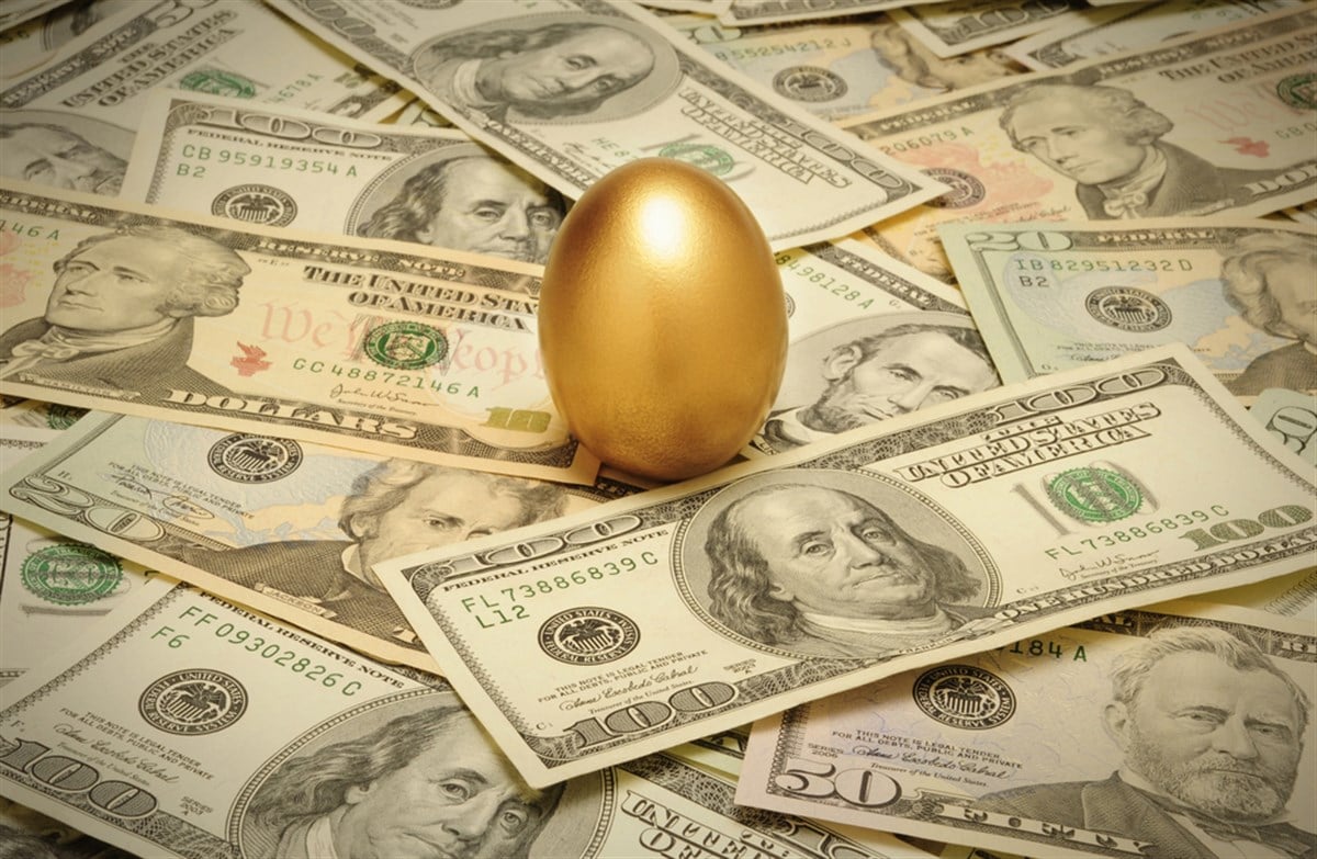 Gold nest egg on a layer of cash — Photo