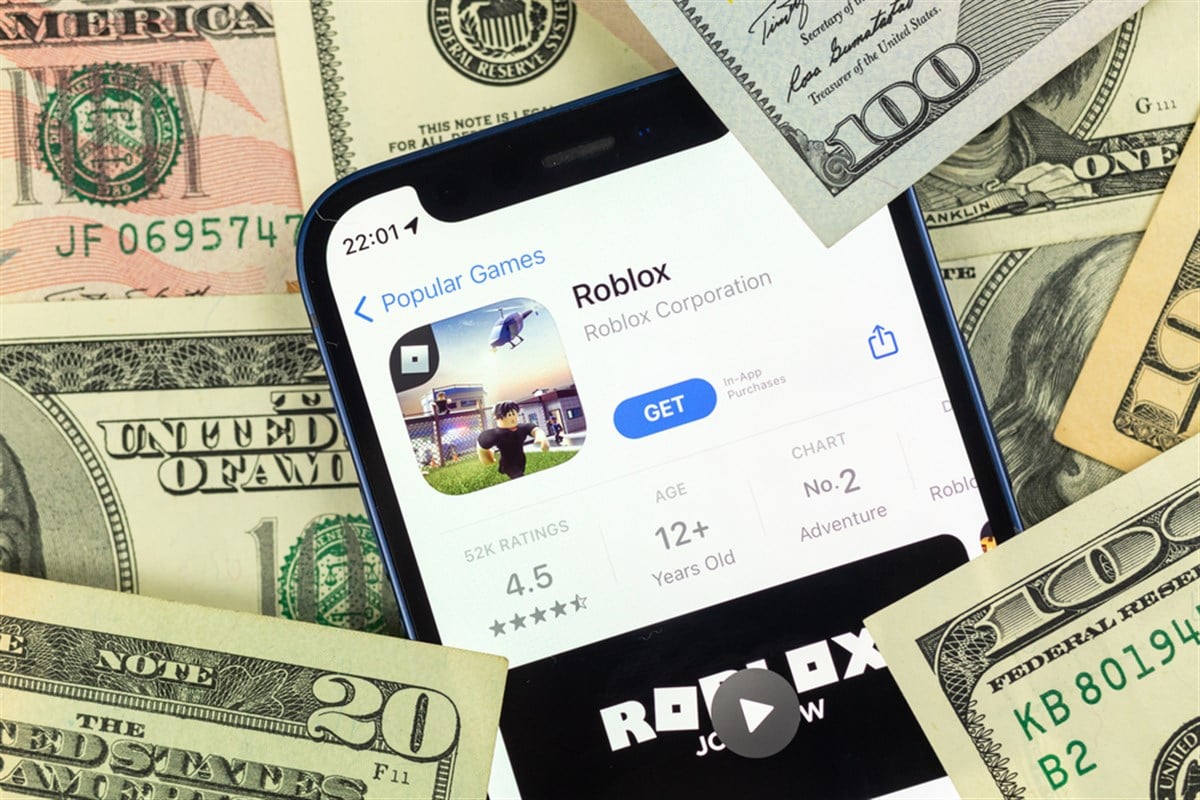 Kharkov, Ukraine - January 19, 2022: Roblox mobile game app and money background photo — Stock Editorial Photography