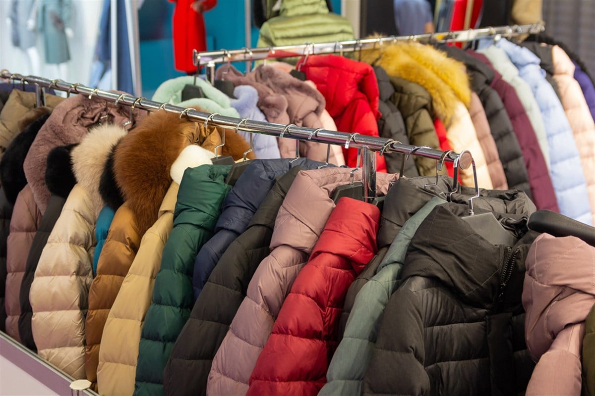 Fashionable men's and women's coat on hangers in a modern clothing store — Photo