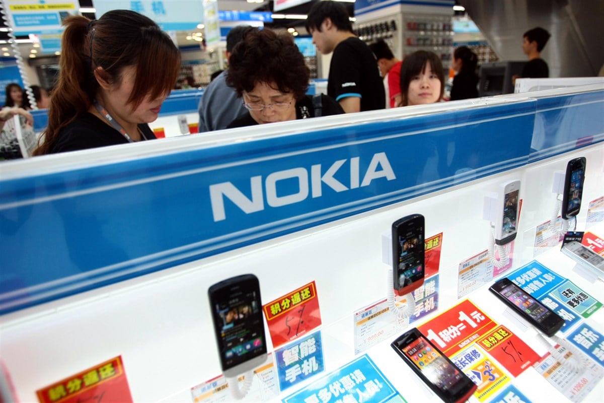 Chinese shoppers buy Nokia smartphones at the Laox flaship store in Shanghai, China, 25 May 2012.Nokia Corp, which is struggling to survive as it competes with iPhone and Android phones, will cut jobs in China, its biggest regional market. Its four d