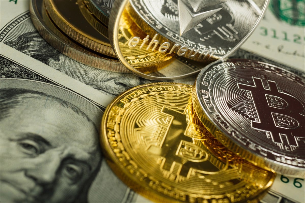 Bitcoin coin with other cryptocurrency on dollar notes - Stock Editorial Photography