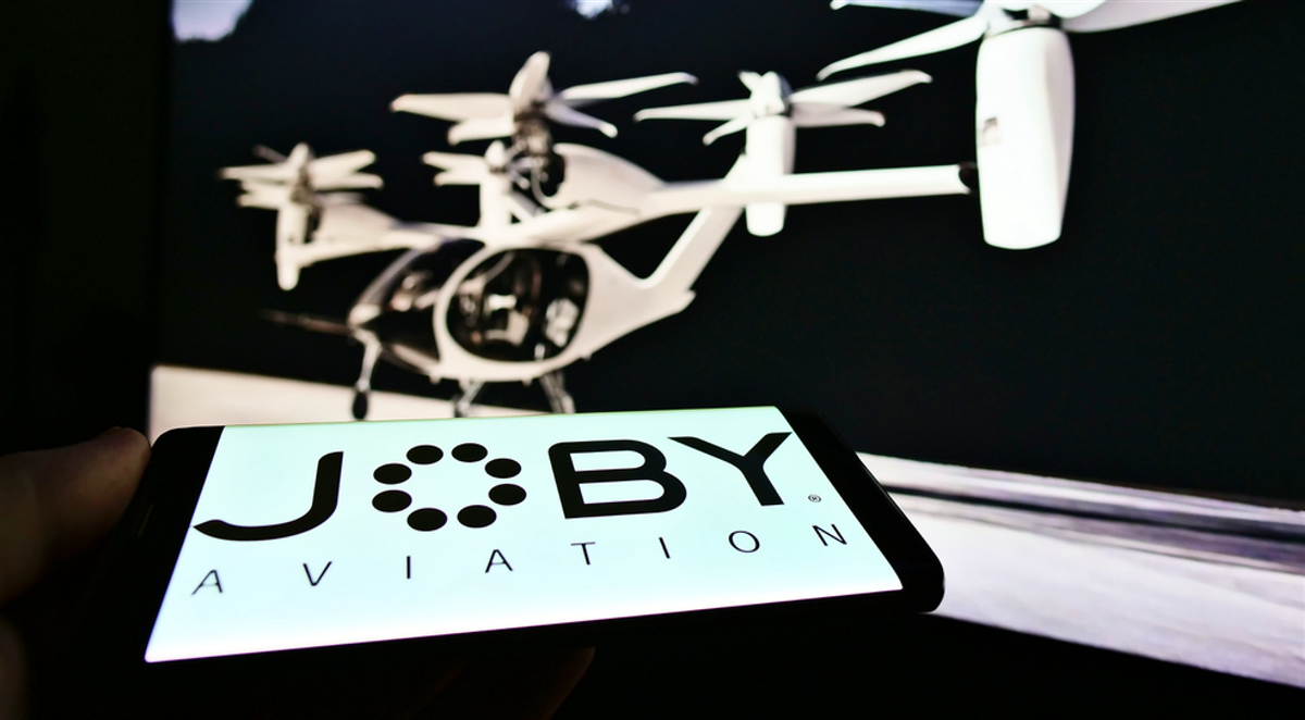 STUTTG, GERMANY - Jan 23, 2021: Person holding smartphone with logo of aerospace company Joby Aviation (air taxi) on screen. Focus on top center of phone display. — Stock Editorial Photography