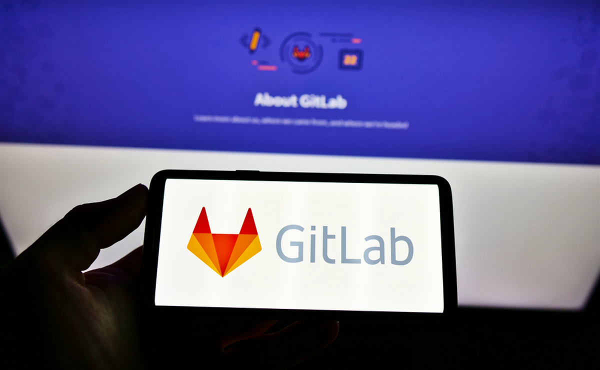 STUTTGART, GERMANY - Mar 03, 2021: High angle view of person holding mobile phone with logo of US DevOps platform GitLab Inc. on screen in front of website. Focus on cellphone display. — Stock Editorial Photography