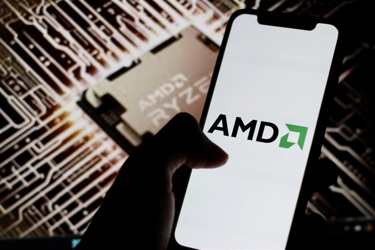 AMD logo is displayed on smartphone screen with chip AMD Ryzen in background. — Stock Editorial Photography