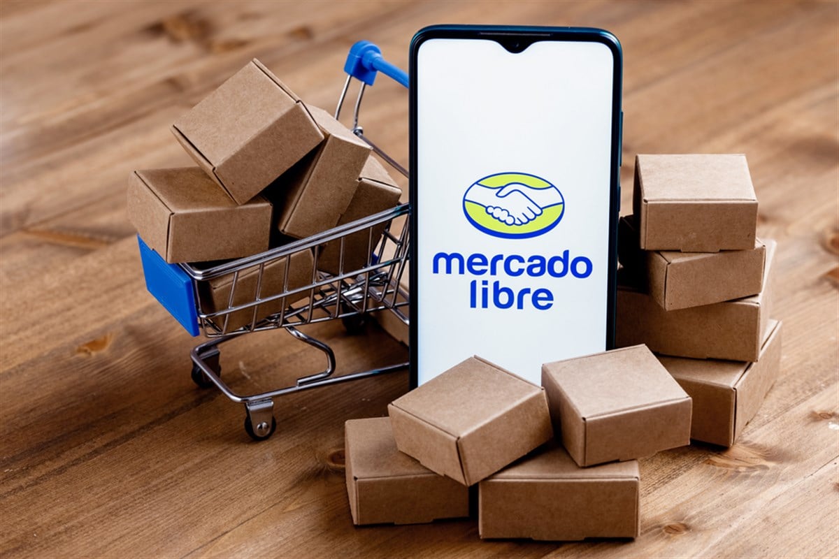 Kazan, Russia - Oct 22, 2021: Mercado Libre is Argentine company that operates online marketplaces. Smartphone with Mercado Libre logo on the screen, shopping cart and parcels. - Stock Editorial Photography