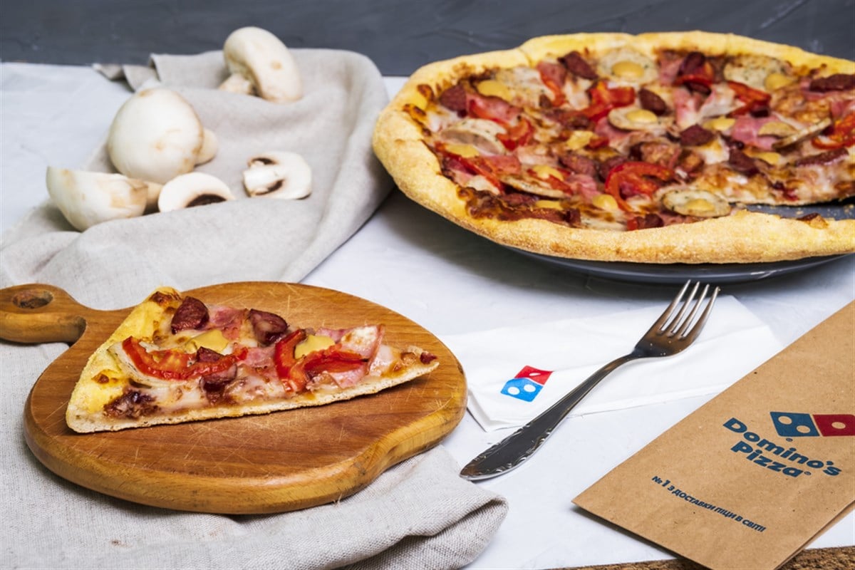 Photo of a Domino's pizza pie set on a table.