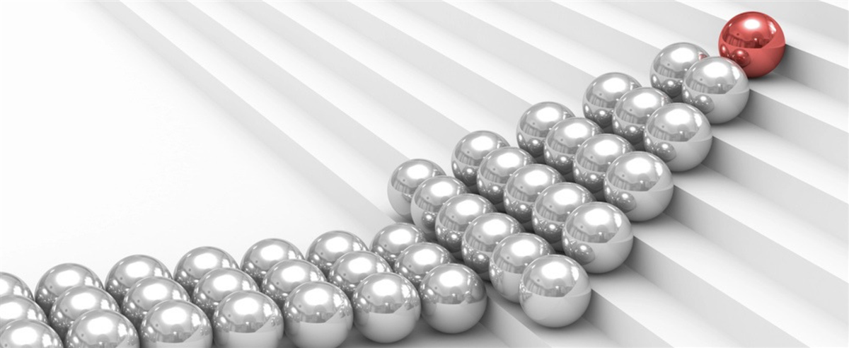 Photo of silver balls making the shape of an arrow, with a red ball at the tip; symbolizing how leadership can increase company value