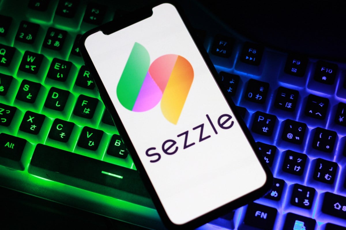 Close up view of the smartphone on neon keyboard with sezzle logo — Stock Editorial Photography