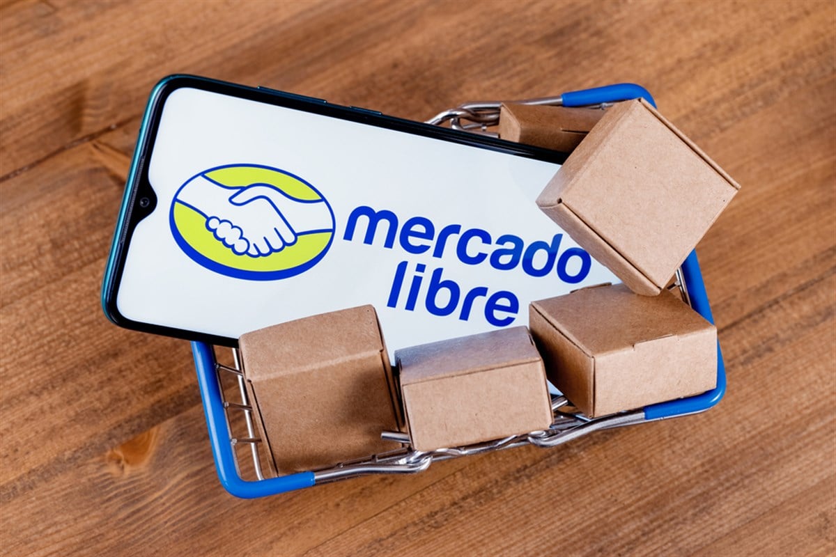 Kazan, Russia - Oct 22, 2021: Mercado Libre is Argentine company that operates online marketplaces. Smartphone with Mercado Libre logo on the screen, shopping cart and parcels. - Stock Editorial Photography