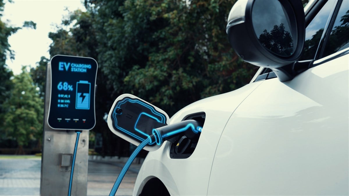 Electric car plugged in with charging station to recharge battery with electricity by EV charger cable in eco green park and greenery foliage. Future innovative ev car and energy sustainability.Peruse — Photo