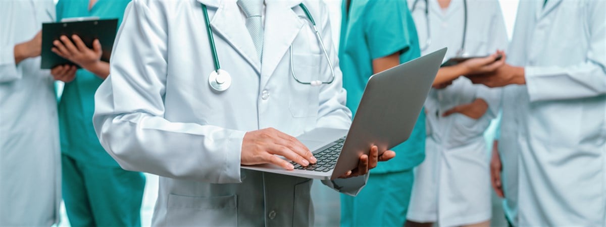 Medical staff team with doctor nurse and healthcare specialist professions working together with laptop and tablet in hospital. Medical workplace and healthcare community in panoramic banner. Neoteric — Photo