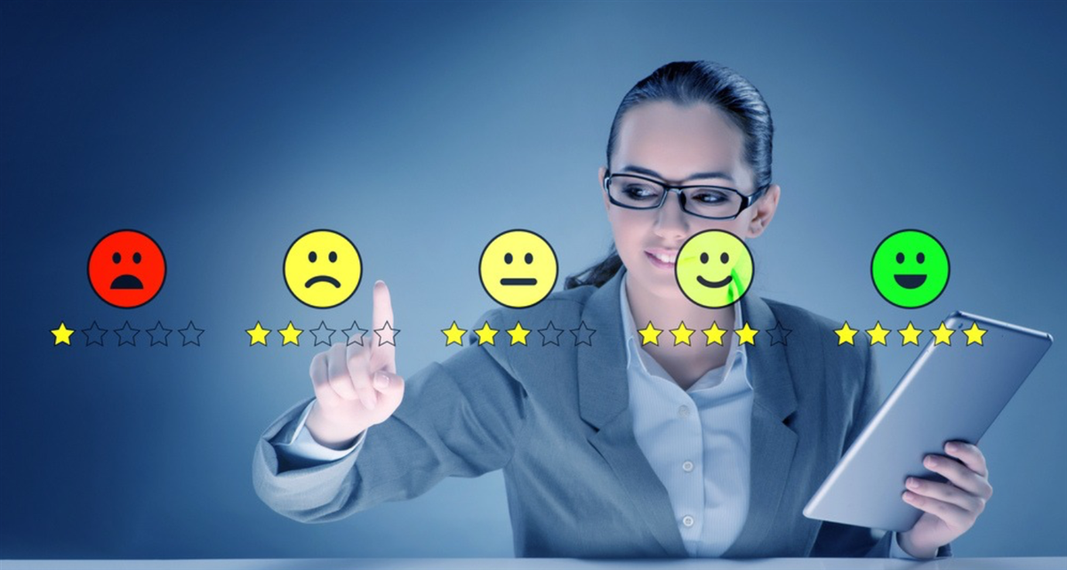 Photo of a woman selecting from colorful smiley faces, pointing at the second worst smiley